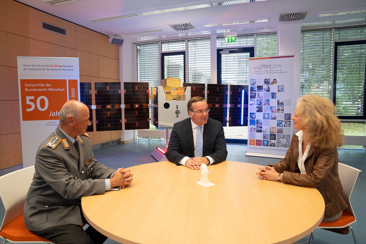 An einem runden Tisch sitzen links im Bild Oberst Henkelmann, in der Mitte Verteidigungsminister Pistorius und rechts im Bild Präsidentin Kern