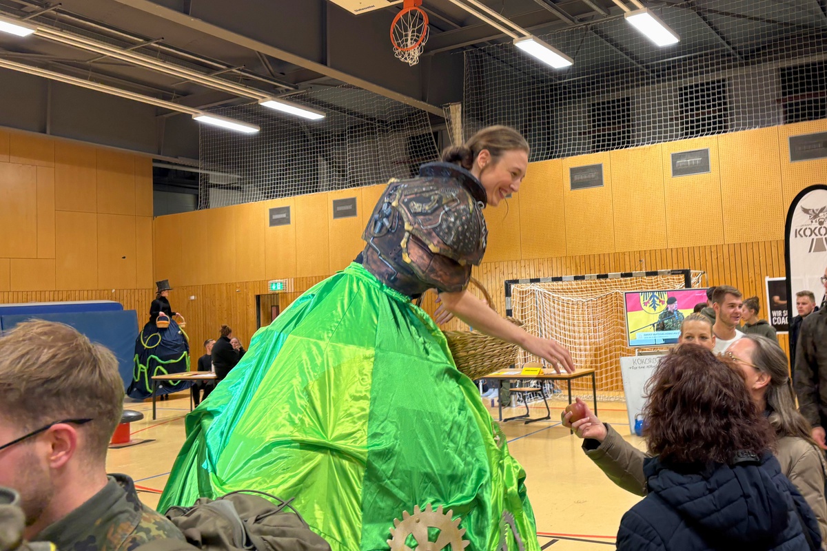 Turnerinnen auf Stelzen verteilen Äpfel