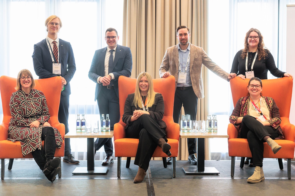 Die sieben Organisatoren des DIPD in orangenen Sesseln und stehend