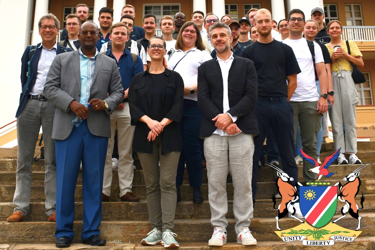 Gruppenfoto der Namibia-Exkursions-Klasse mit zwei Referenten der Konrad-Adenauer-Stiftung vor dem Parlament Namibias