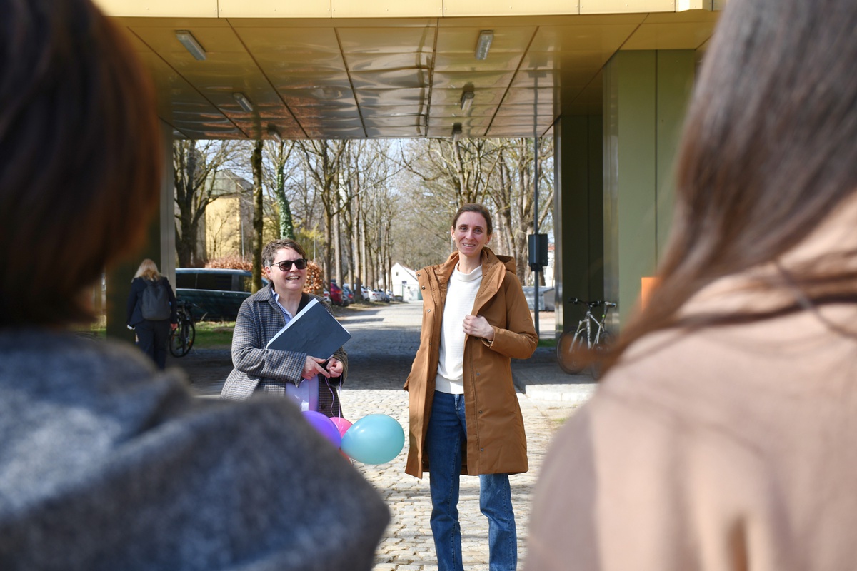 Im Vordergrund sind zwei Hinterköpfe zu sehen. Durch die Lücke zwischen den Köpfen sieht man Prof Julia Reif und Kornelia Reischl von der zivilen Gleichstellungsstelle.