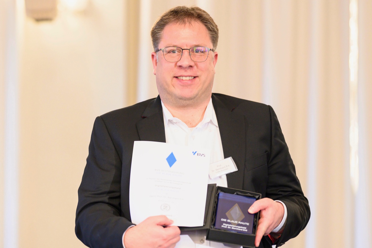 Prof. Bernhard Ertl mit Urkunde und Blauer Raute