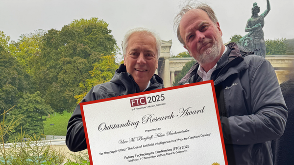 Prof. Uwe M. Borghoff und Prof. Klaus Buchenrieder mit der Urkunde im Vordergrund