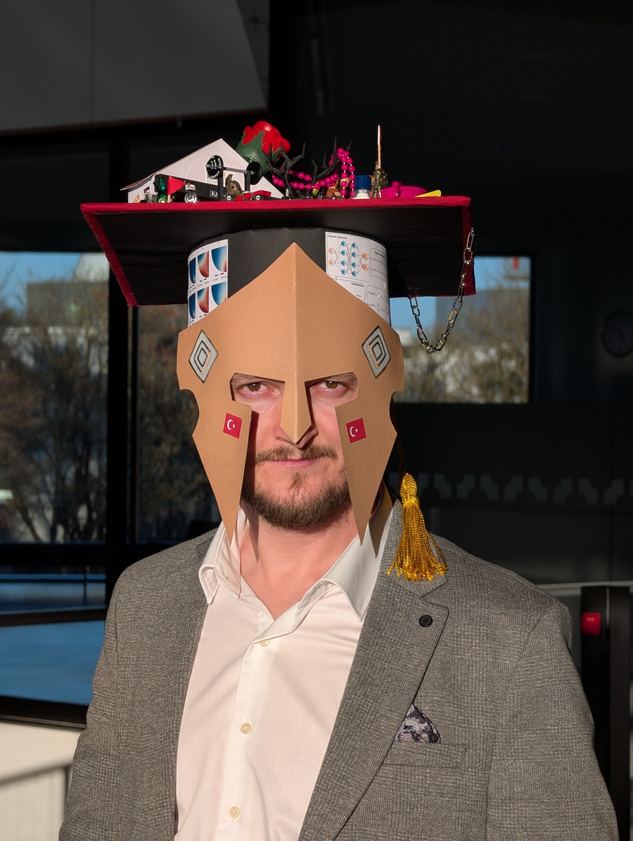 Der frisch gebackene Doktor Tarik Sahin mit dem von seinen Kolleginnen und Kollegen liebevoll gestalteten Doktorhut.